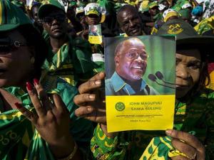 A supporter holds a booklet with a photo of Tanzanian President John Magufuli at a rally by ruling party Chama Cha Mapinduzi (CCM) in Dar es Salaam, Tanzania. CCM has emerged united contrary to earlier speculation of an expected fall out. AFP PHOTO | DANI